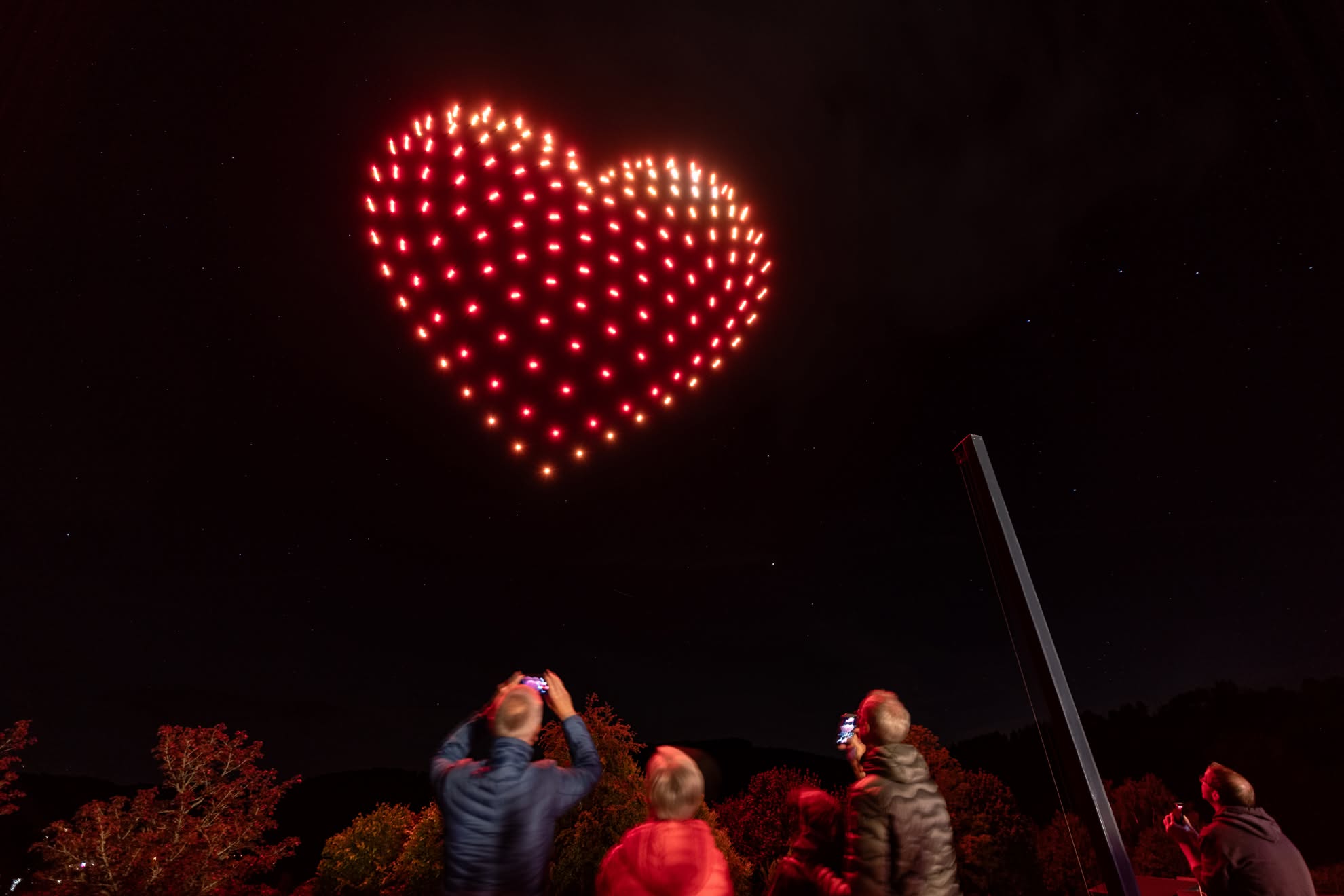 A red heart of drones over the crowd