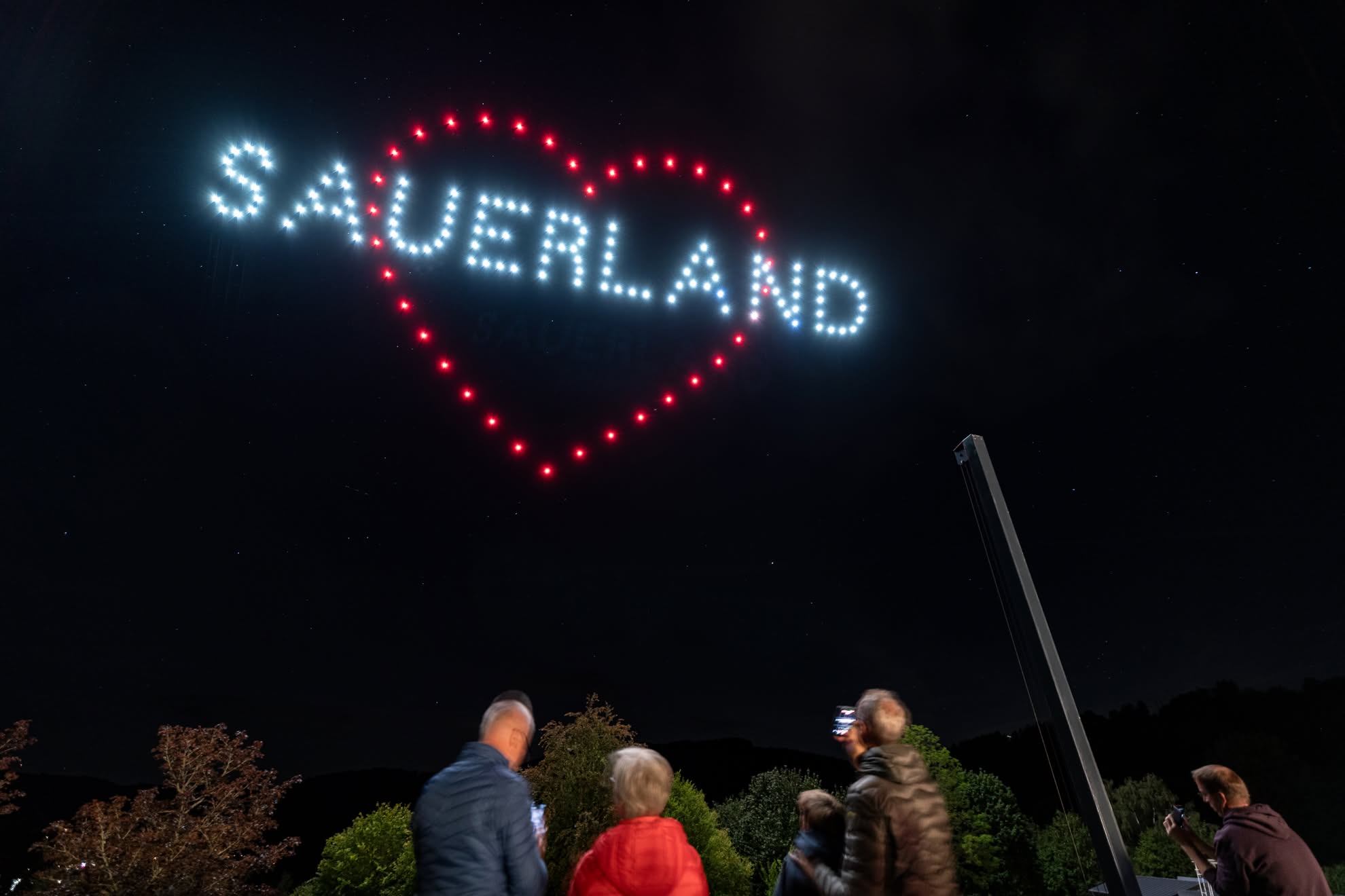 SAUERLAND written in drones inside a red heart, over the crowd