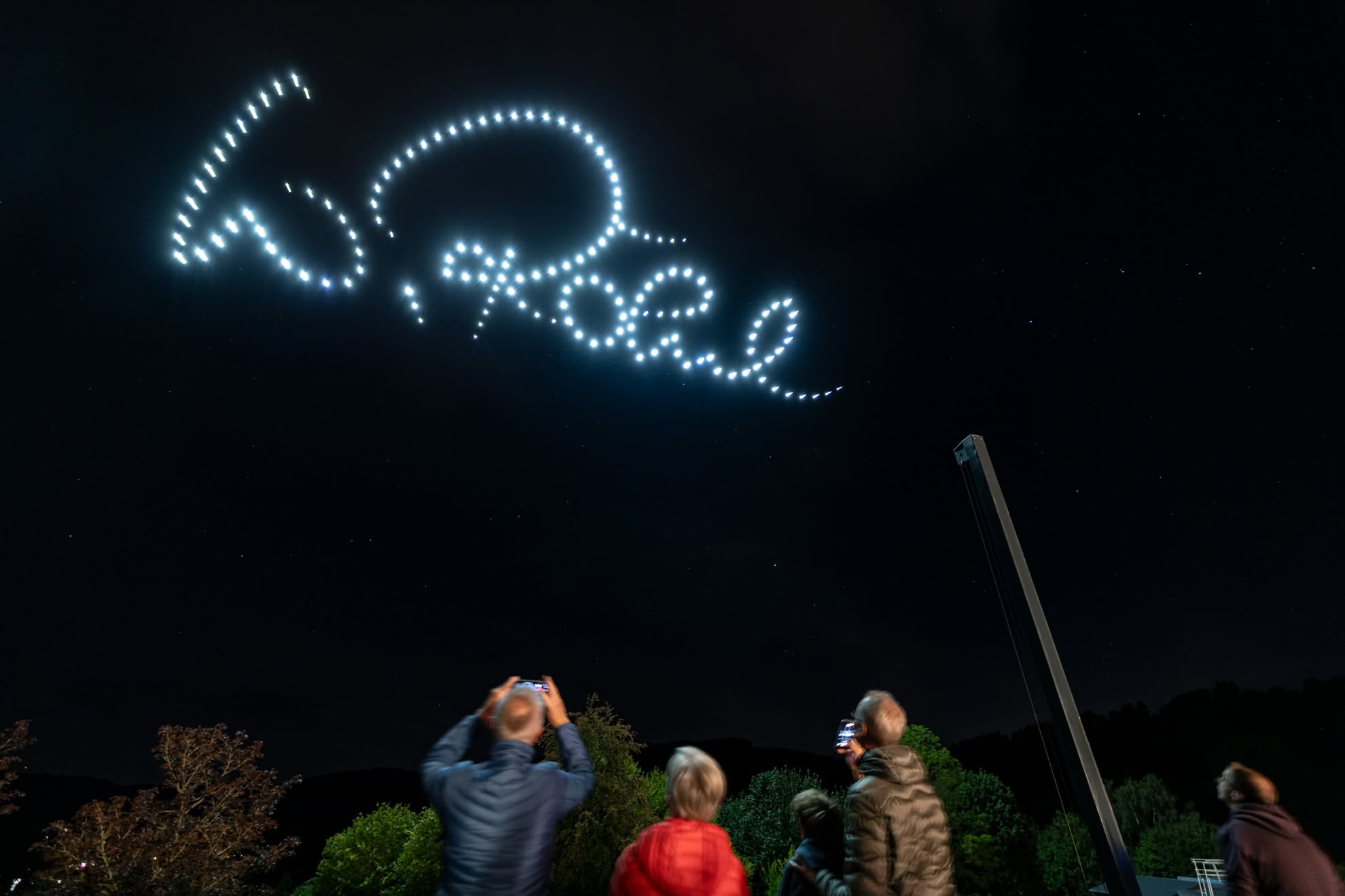 Walter Röhrl’s signature in drones over spectators at night